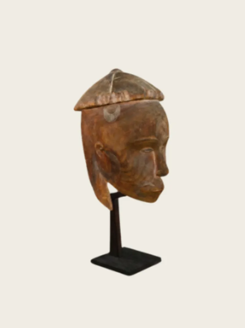 Carved wooden African head sculpture on display.